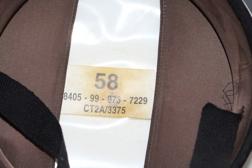 A Russian sailors cap with numbered label and attached skull and crossbones badge, and a steel helmet with original leather fittings